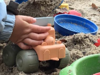 Barn, der leger i sandkassen